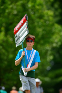 Teenage boy volunteers as standard bearer at the Meijer LPGA Classic for Simply Give