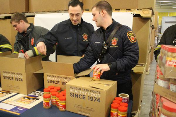 Wauwatosa Fire Department packing boxes with peanut butter jars for Hunger Task Forces' Wanted: Peanut Butter campaign