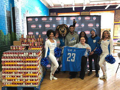 Detroit Lions cornerback Darius Slay, cheerleaders and mascot Roary with Meijer team members at Gleaners Food Bank donation