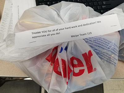A goodie bag full of snacks, baked goods and energy drinks with a note of appreciation for Meijer truck driver