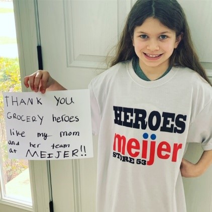 Store director's daughter in Meijer t-shirt, holding message 