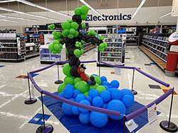 A balloon sculpture of on island with a man reclining under a tree in the center aisle of Meijer in Cincinnati, Ohio