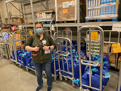 Meijer team member with meal kits containing shelf stable food items for the Boys and Girls Club of Washington County