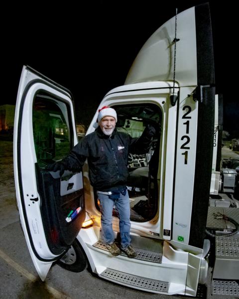 Meijer team member of 50 years, in Santa hat standing in door of a Meijer truck