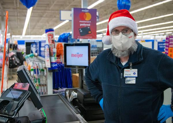 Cashier Phil Kolburn, Meijer team member of 50 years, dressed in Santa hat at checkout