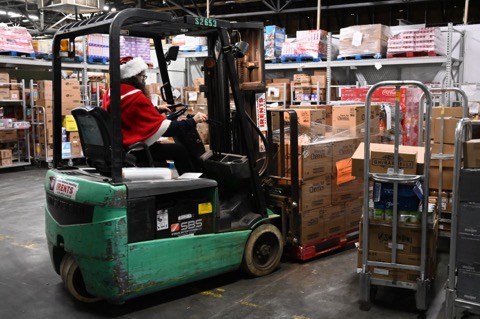 Meijer Grocery Inventory Coordinator Pat Otterson drives a fork lift with boxes of food for the McHenry Knights of Columbus Holiday Food Drive.