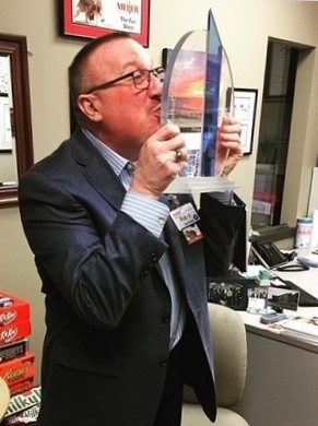 Meijer Store Director Rob Vassar kisses a trophy his store received for cleanliness.