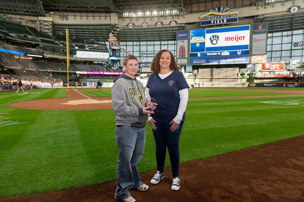 Autism Society of Southeast Wisconsin representatives with “Community MVP” award on Milwaukee Brewers field.