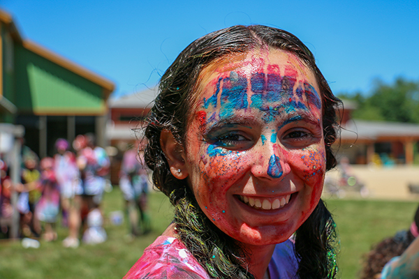 Lindsey Offenburger smiles while covered in paint at Flying Horse Farms camp.