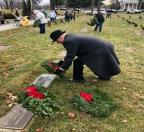 National Wreaths Across America Day participants laying live balsam wreaths on veterans’ grave sites