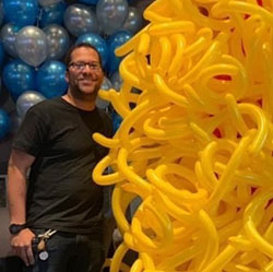 David Baker, local Cincinnati, Ohio artist and part-time Meijer team member posing with a balloon sculpture