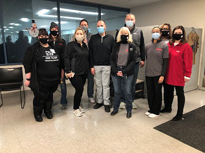 10 Meijer team members stand in the Gleaners break room wearing masks before their volunteer shift begins.