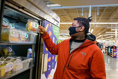 A customer picks a pre-packaged salad out of the Flash Food refrigerator.