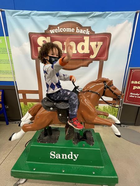 Milo Greenlee-Wognum riding Sandy the Pony at Meijer