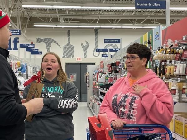 Two customers are surprised with a shopping spree by a store director