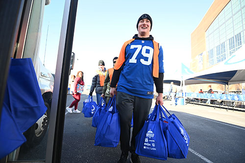Colts player Bernhard Raimann carrying meals at 2022 Horseshoe Helpings event