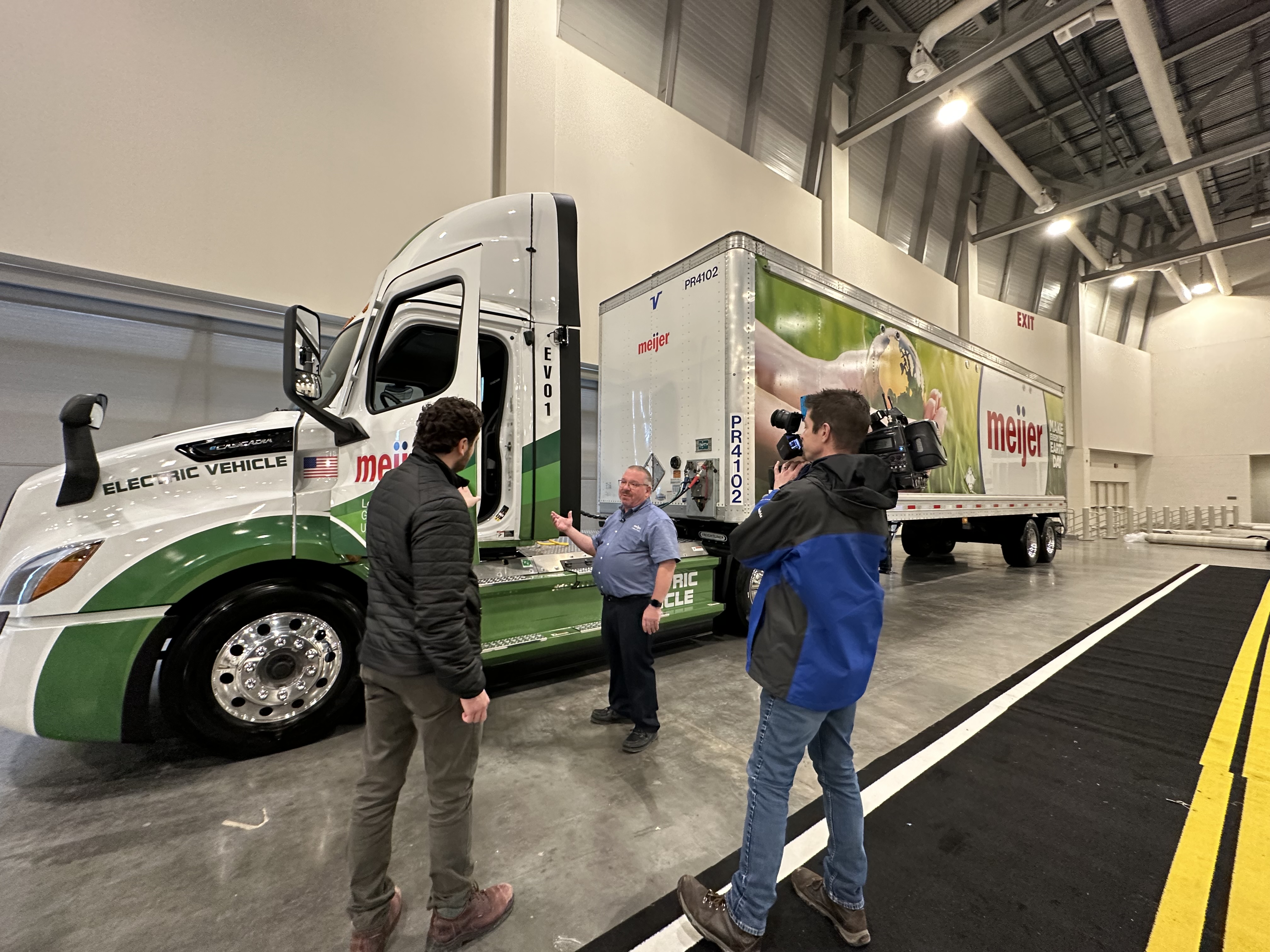 Dave Hoover, Director of Outbound Logistics at Meijer, gives a tour of the retailer’s Electric Semi-Truck to a news crew at the 2023 Michigan International Auto Show