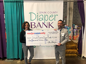 Jackson Township Meijer Store Director Marco Gomez holds a $5,000 check with Stark County Diaper Bank Founder Shannon English-Hexamer.